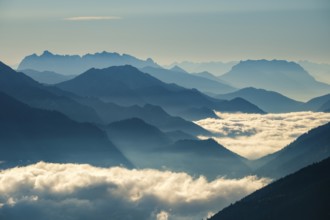 Blue-colored silhouette of mountains, fog in the valley, Wilder Kaiser and Chiemgau Alps, Upper