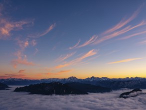 Red-colored plume clouds over the Berchtesgaden Alps at dusk, fog in the valley, Hochstaufen,