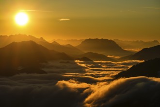 Silhouette of mountains at sunset, fog in valley, Wilder Kaiser and Chiemgau Alps, Upper Bavaria,