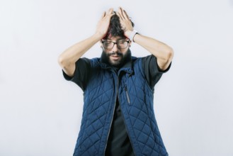 Painful man with a migraine holding his head isolated. Unhappy man with headache concept