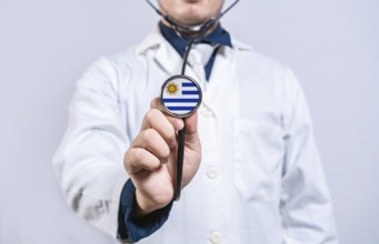 Doctor hands holding stethoscope with Uruguay flag. Uruguay health and care concept