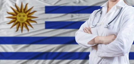 Doctor with crossed arms on Uruguay flag. Uruguay health and care concept. Female doctor on Uruguay
