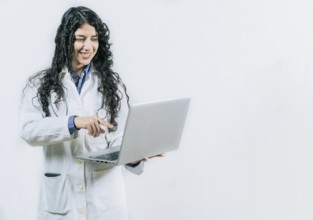 Female young doctor using and pointing laptop isolated. Smiling Woman doctor using laptop on