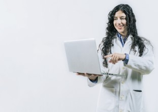Smiling Woman doctor using laptop on isolated background. Female young doctor using and pointing