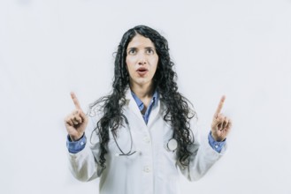 Surprised female doctor pointing up. Young female doctor looking and pointing promotion up isolated