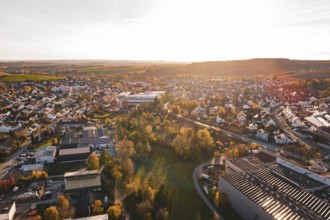 Expansive view of a city in autumn evening light with many trees, Großbottwar, Germany