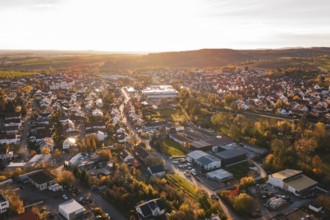 Extensive settlement surrounded by fields and trees in autumn at sunset, Großbottwar, Germany