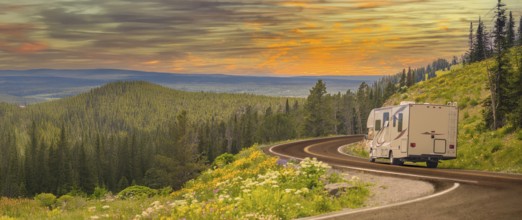 Camper driving down road in the beautiful countryside among pine trees and flowers