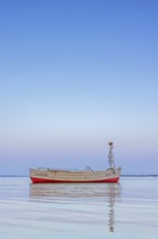 Wooden fishing boat anchored in the Bay of Lübeck, Lübecker Bucht in front of Sierksdorf at sunset,