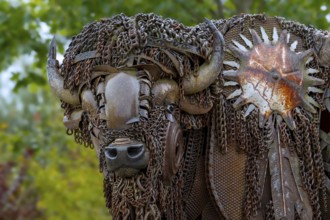Close-up of life-size bison metal sculpture made out of discarded farm equipment, chains and bronze