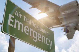 Air traffic control emergency green road sign with airplane above