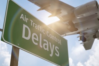 Air traffic control delays green road sign with airplane above