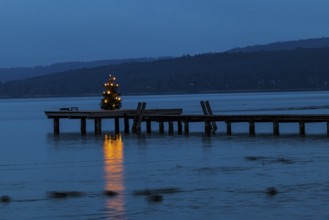 Illuminated Christmas tree at dawn, on a boat dock, Dießen am Lake Ammer, Upper Bavaria, Bavaria,