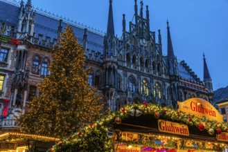 Mulled wine stand at the Christmas market, in the back the new town hall with illuminated Christmas