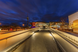 Evening atmosphere at BMW World, Johanna and Herbert Quandt bridge, in the back the TV tower in the