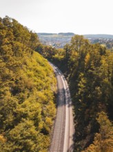 Railway tracks through autumn landscape with views of hills and trees, Bau der Hermann, Hesse,