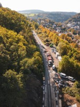 Construction site next to railroad tracks in an autumn landscape with a view of a village, Bau der