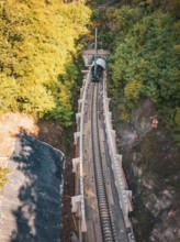 Aerial view of a rail construction site in the forest with tunnel boring machine and workers,