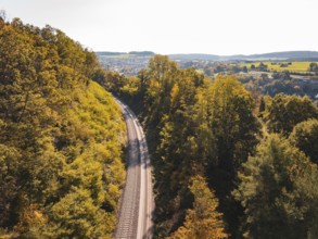 Autumn landscape with railroad tracks and trees, view of hills, building of Hermann, Hesse,