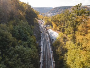 Autumn landscape with construction on railroad tracks and surrounding forest in the sun, Bau der