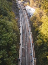 Rail system in a wooded, autumnal area with ongoing construction, construction of Hermann, Hesse,