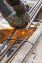A worker cuts metal bars with a flex, sparks spray, construction of Hermann, Hesse, Bahn, Calw,