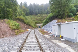 Railroad tracks lead through wooded landscape to a tunnel opening, construction of Hermann, Hesse,