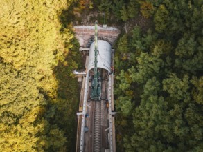 Aerial view of a construction site with a tunnel boring machine in a wooded area on railroad