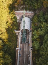 A bird's eye view of crane construction during tunnel construction in an autumnal landscape,