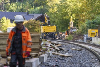 A worker on a construction site with construction machinery in the background, Bau der Hermann,