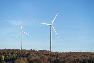 Two wind turbines above a wooded hill under a blue sky, Swabian Jura, Baden-Württemberg, Germany