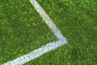Green artificial turf creating a textured background with a white painted line marking a corner of
