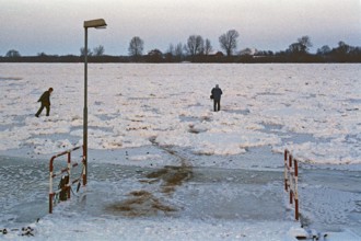 People walk across ice rink, ferry dock, frozen Elbe, Bleckede, Lower Saxony, Germany, January 03,