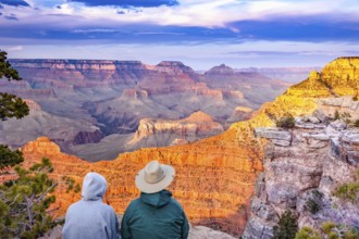 Couple enjoying the beautiful landscape of the grand canyon sunset