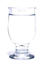 Glass with mineral water, small carbonated pearls on the edge of the glass, drinking water