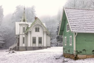 Idyllic old wooden house with beautiful carpentry and a garden shed a frosty and snowy cold misty