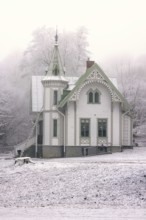 Idyllic old wooden house with beautiful carpentry a frosty and snowy cold misty winter day,