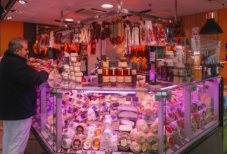 Market stall shop store selling cheese and delicatessen meat products inside Mercado Central de