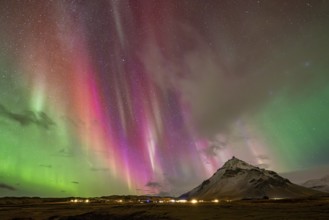 Northern lights, aurora borealis over mountain, Arnastapi, Iceland