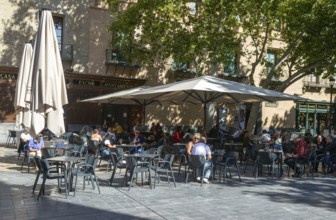 People sitting at tables and chairs in courtyard, Plaza de San Filipe, Zaragoza, Aragon, Spain