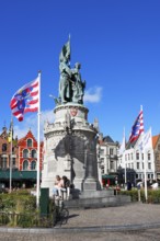 Monumental monument to Jan Breydel and Pieter de Coninck and flags of Bruges in front of historic