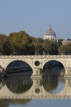 Bridge over the river Tiber with the dome of St. Peter's Basilica in the Vatican city in the