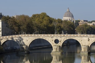 Bridge over the river Tiber with the dome of St. Peter's Basilica in the Vatican city in the