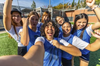 Young diverse women's soccer team playing a championship, celebrating a goal or victory together