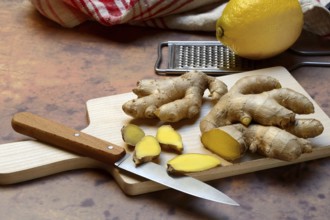 Ginger, ginger root cut with ginger slices on wooden boards