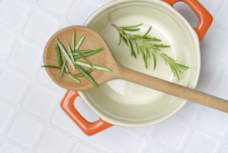 Rosemary, rosemary leaves on cooking spoon with cooking pot