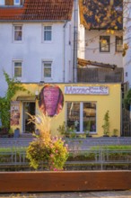 Small pizzeria with yellow façade in the midst of a colorful autumn backdrop, Aidlingen, Böblingen
