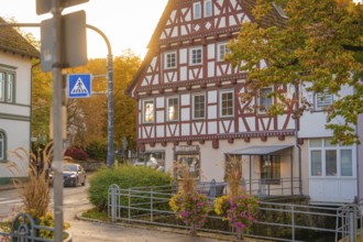 Cosy half-timbered house in autumn light with street sign and flowers, Aidlingen, Böblingen