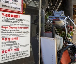 Sign trash removal prohibited, bulky waste in a spoiled house entrance, Shinjuku City, Tokyo, Japan