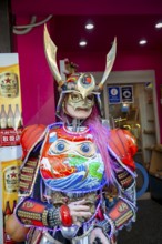 Futuristically dressed mannequin with colorful armor, cosplay, in front of a restaurant, Shinjuku